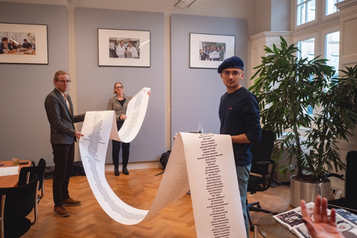 Hester Bijl (back), Rik Jongenelen (left) and Nima Hakim (right) hold the long list of missing Iranians