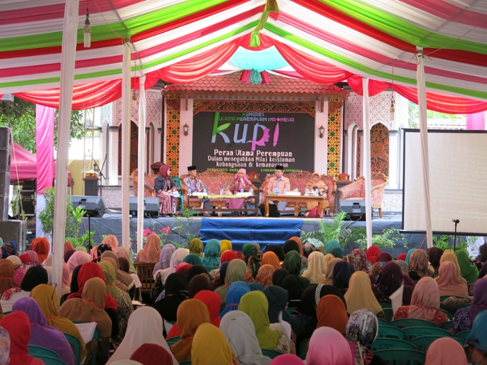 A packed hall with only veiled women listening to five speakers from the Indonesia Women's Ulama Congress (Kongres Ulama Perempun Indonesia) van 2017. Drie van de sprekers zijn vrouw, twee zijn man.