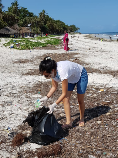 Student of Leiden University College gathering up plastic waste on the beach in Kenya