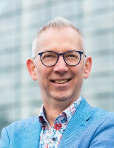 Smiling, older man with glasses.