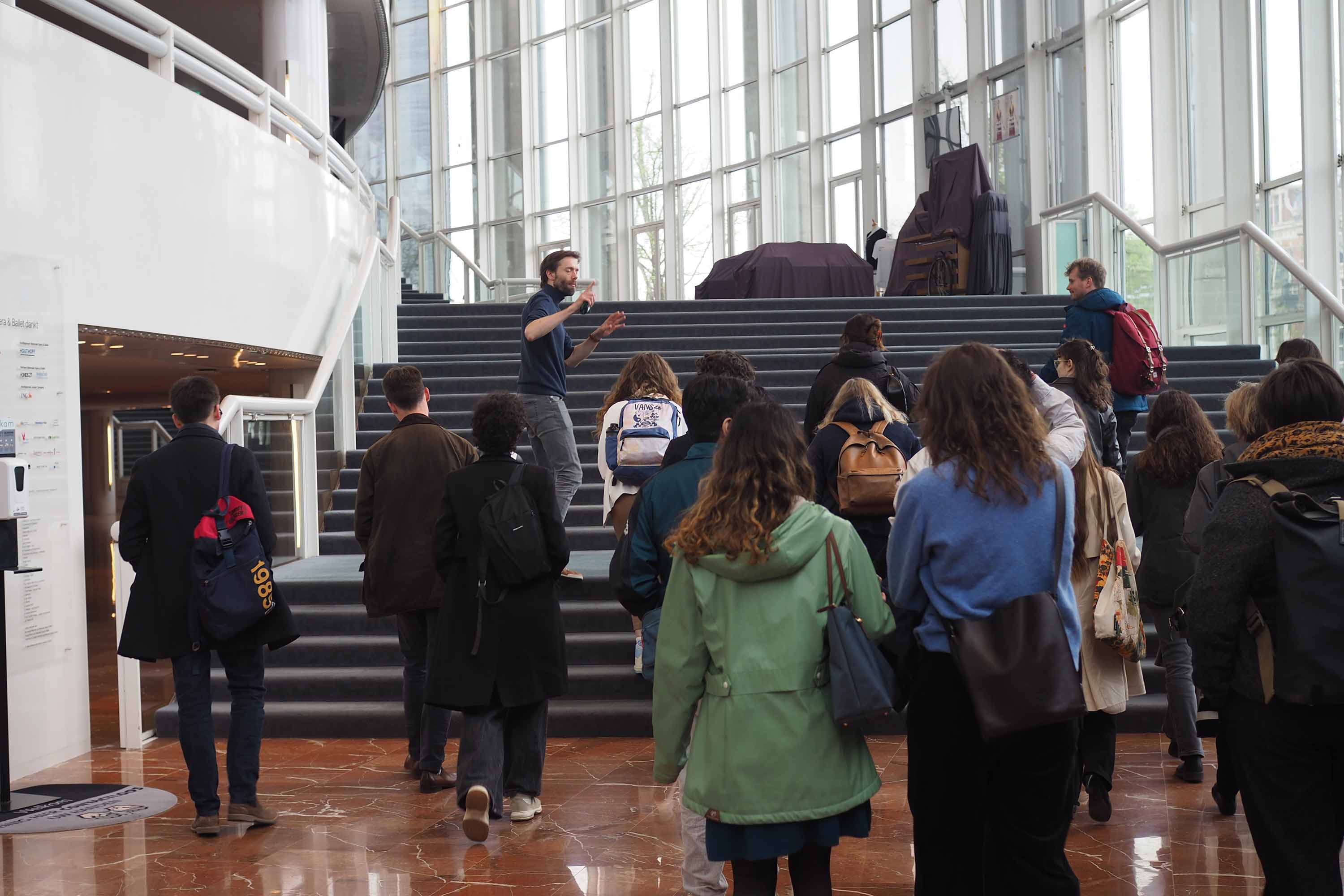National Opera staff member walks up the steps of the opera house with students.