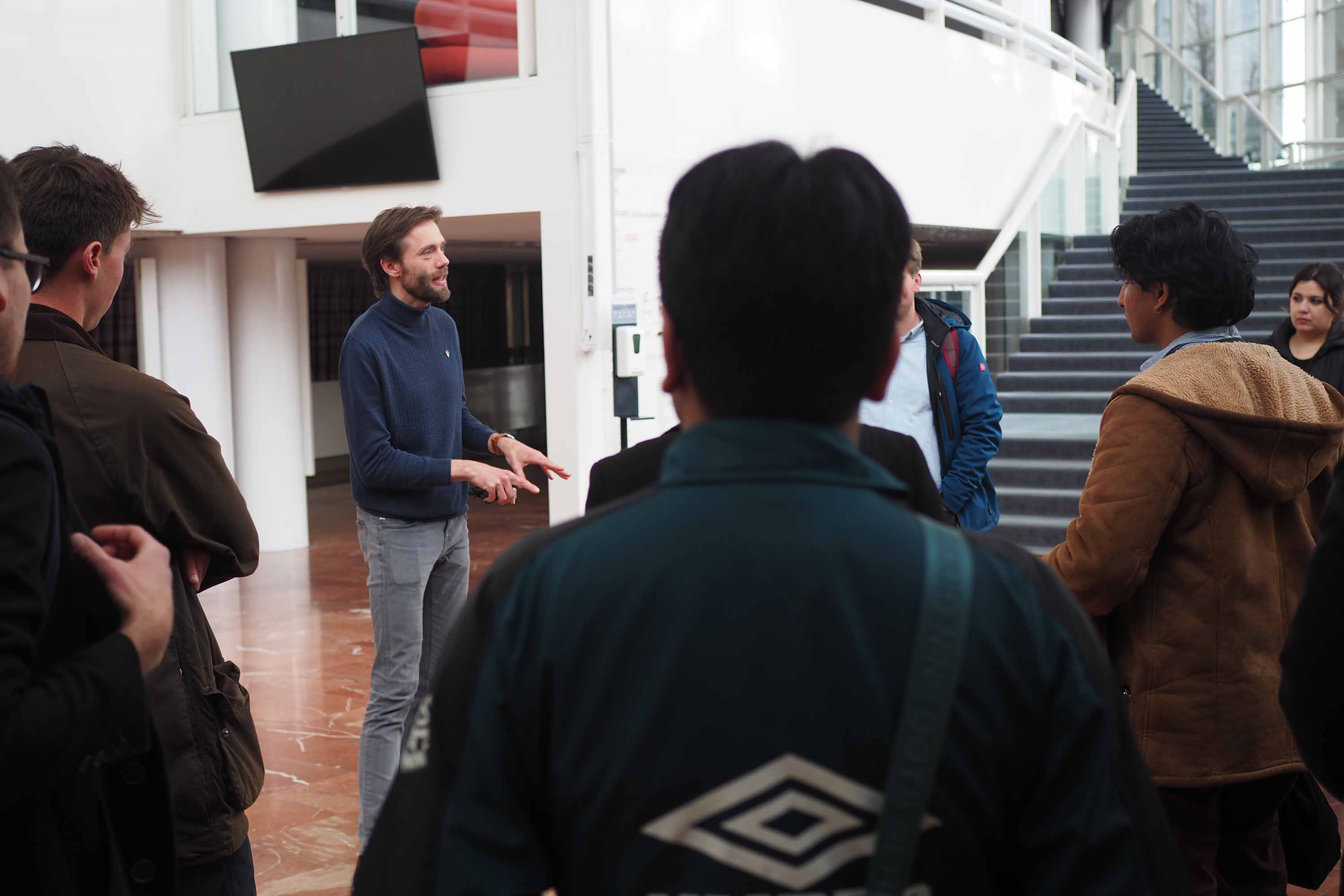 A National Opera staff member animatedly talks to a group of students.
