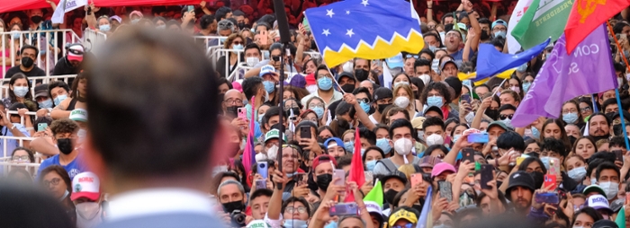 Crowds wave flags at a political rally