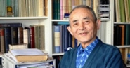 Professor Takamitsu Muraoka in front of a bookcase