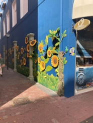 Street corner in Willemstad, Curaçao, with a blue wall with painted sunflowers.