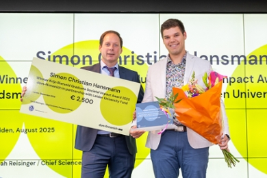 Hans Roubos (left) presents the award to Simon Christian Hansmann.